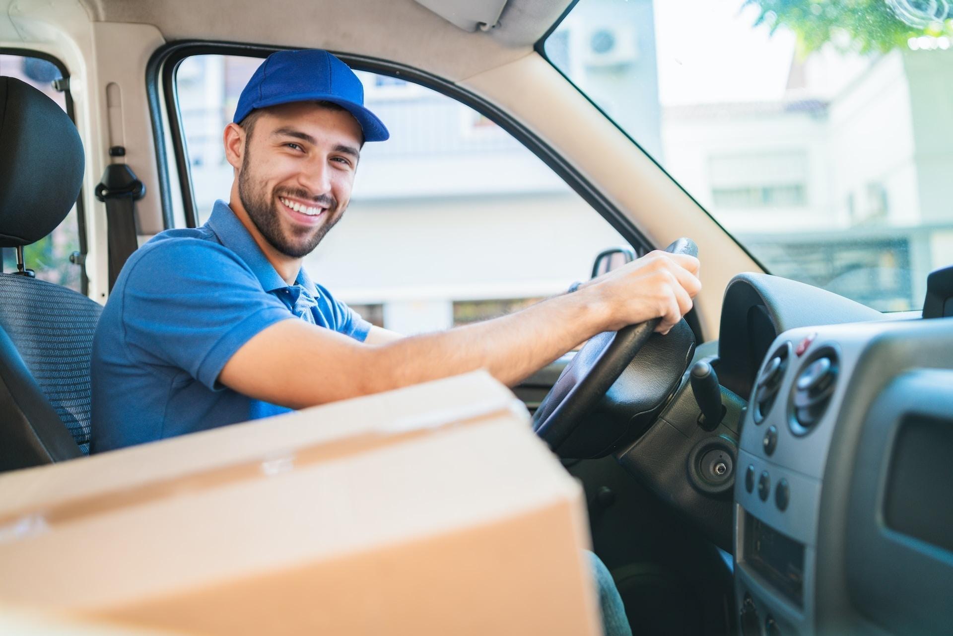 man dressed in blue, driving a car