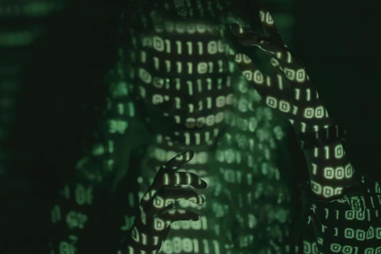 Das Gesicht und die Hand einer Person strecken sich nach einem grün leuchtenden Zahlenmuster aus, grün und schwarz.