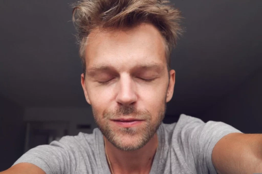 Yeux fermés d'un homme en t-shirt gris