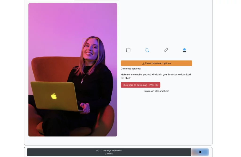 Una mujer joven en una silla naranja y sosteniendo una computadora portátil Apple en su regazo con un atuendo negro sonriendo y la imagen lista para ser descargada después de usar la función Cambiar expresiones de EraseID